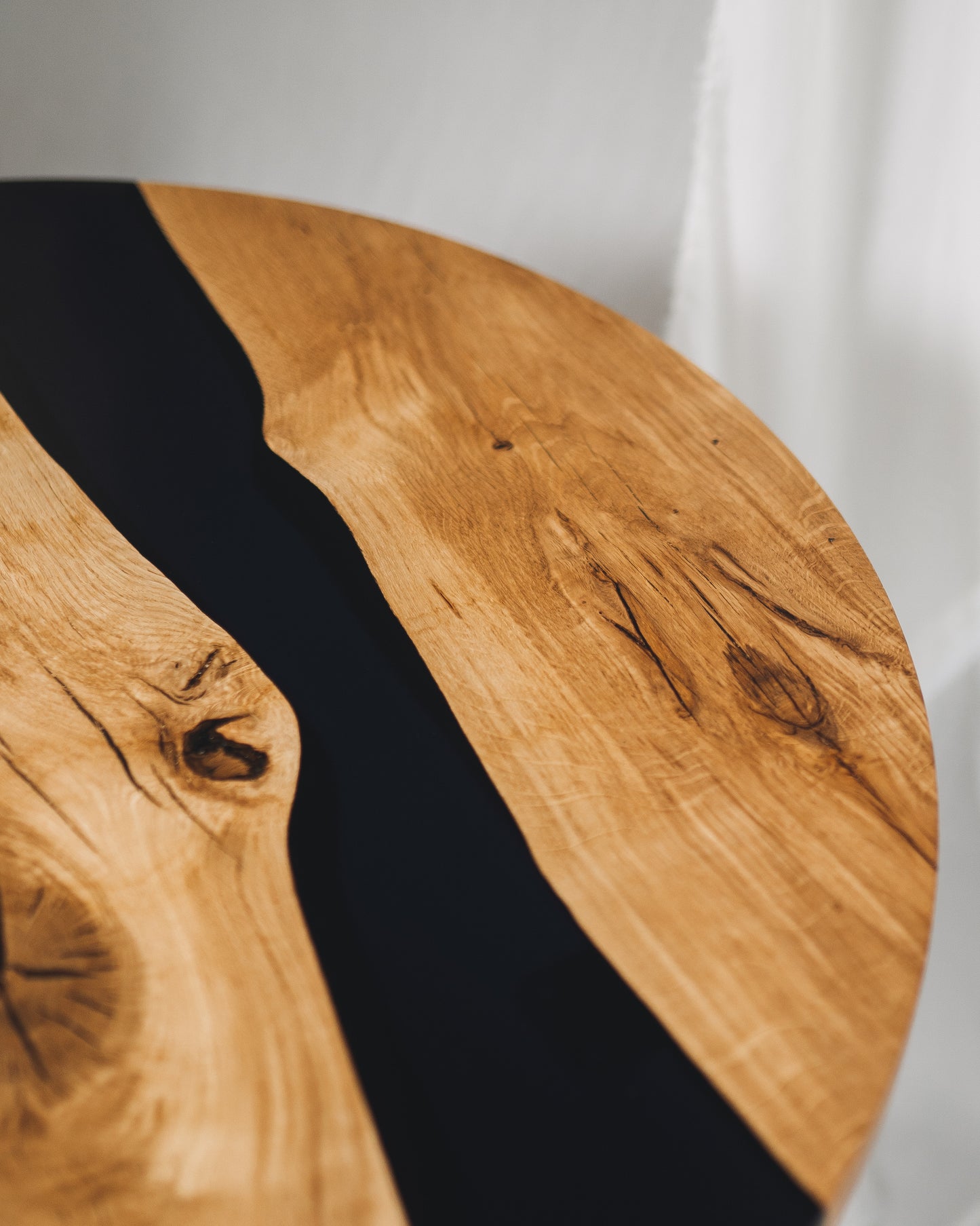 Close-up of black epoxy river in solid oak tabletop